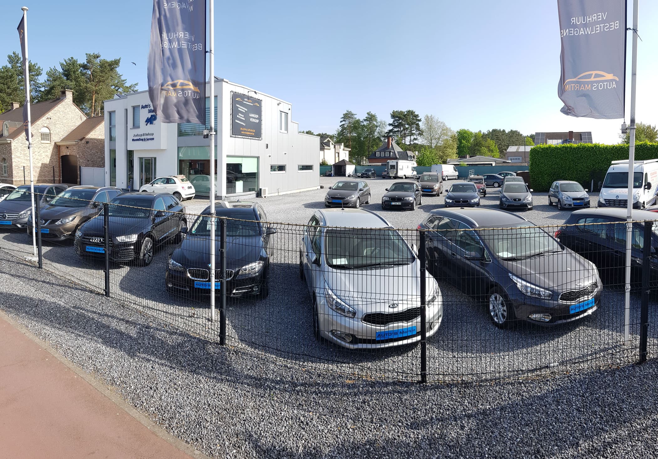 Het terrein van Auto's Martin in Heusden-Zolder met tweedehandswagens en de moderne toonzaal